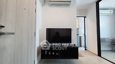 Modern living room with sleek TV setup and air conditioning in a stylish apartment.