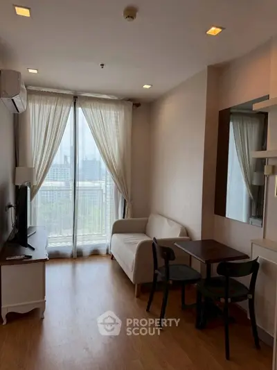 Charming living room with city view, cozy seating, and natural light, perfect for relaxation and entertainment.