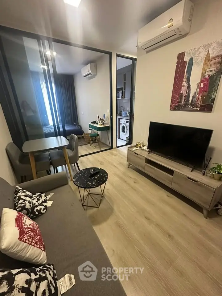 Modern living room with stylish decor, open layout, and natural light, featuring a cozy sofa and sleek TV setup.
