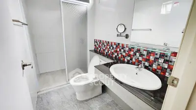 Modern bathroom with stylish mosaic tiles and sleek fixtures.