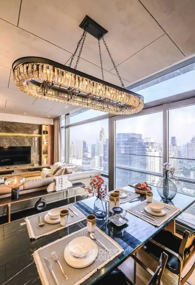 Luxurious dining area with city view, elegant chandelier, and modern decor in high-rise apartment.