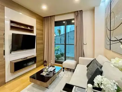 Modern living room with sleek furniture and large window offering natural light.