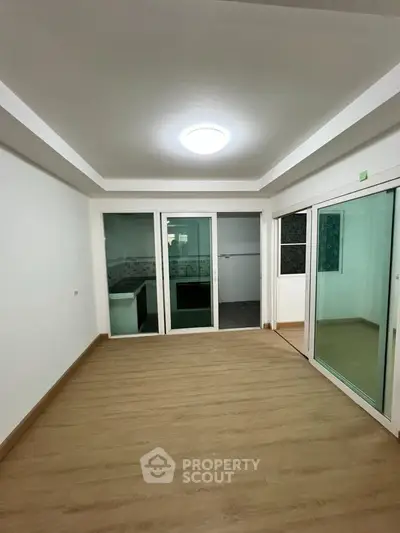 Spacious living room with sliding glass doors and wooden flooring