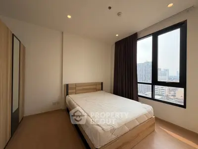 Modern bedroom with large window and city view, featuring a minimalist design and wooden flooring.