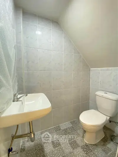 Compact bathroom with modern fixtures and tiled walls, ideal for small spaces.
