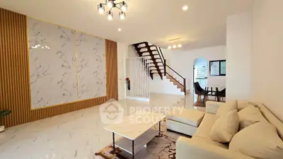 Spacious modern living room with elegant marble accents and stylish staircase