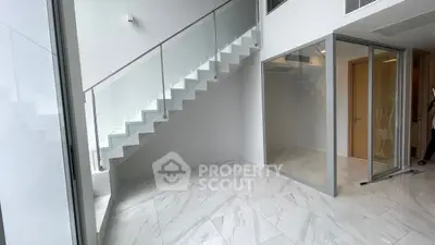 Modern minimalist interior with sleek staircase and glass partitions