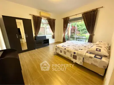 Spacious bedroom with large window and modern furnishings