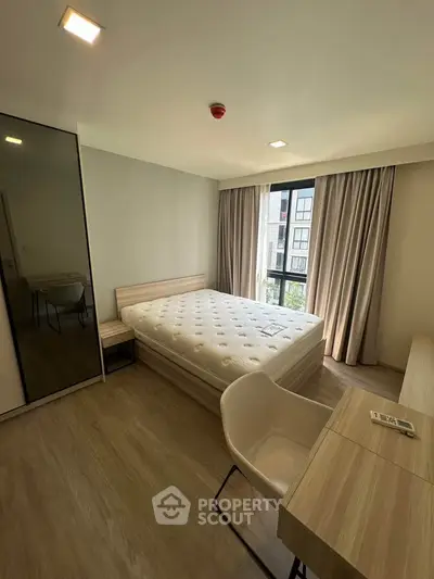 Modern bedroom with large window and stylish furniture in a contemporary apartment.