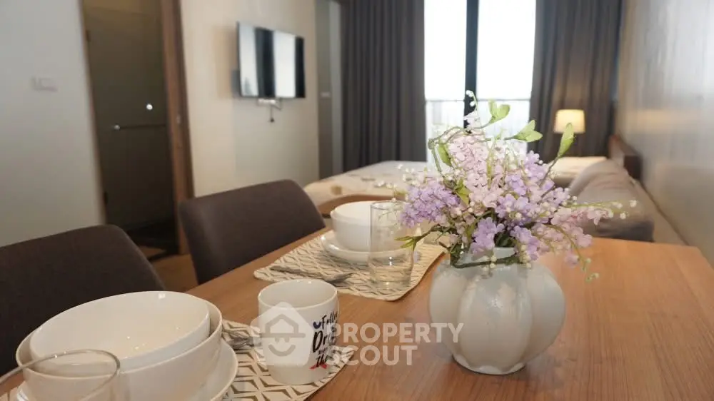 Modern dining area with elegant table setting and cozy living room ambiance.