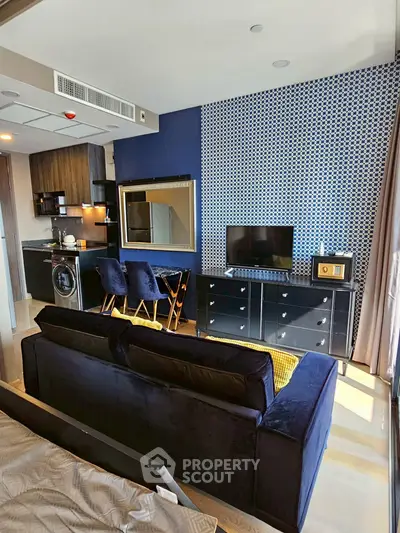 Modern living room with stylish decor, open kitchen, and cozy seating area in a chic apartment.