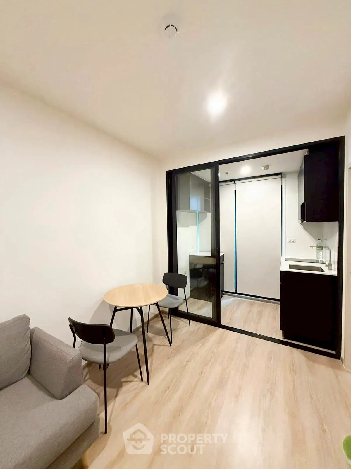 Modern compact living room with open kitchen layout and cozy dining area