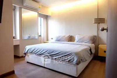 Cozy bedroom with modern decor and ample natural light, featuring a comfortable bed and stylish furnishings.