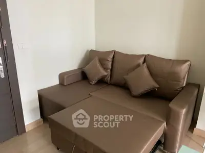 Cozy brown leather sofa in a modern living room corner, perfect for relaxation and comfort.