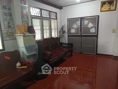 Spacious living room with traditional wooden furniture and large windows for natural light.
