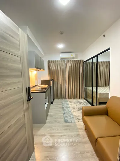 Modern studio apartment with cozy living area and sleek kitchen design