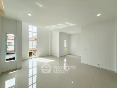 Spacious sunlit room with large windows and glossy tiled floor, perfect for modern living.