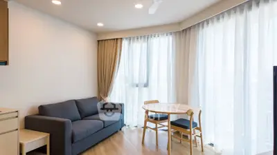 Modern living room with cozy sofa and dining area in bright apartment.