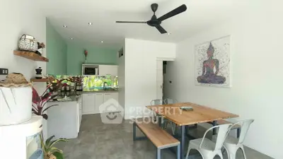 Modern open-plan kitchen and dining area with stylish decor and ceiling fan.