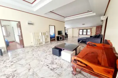 Spacious living room with marble flooring and elegant wooden furniture