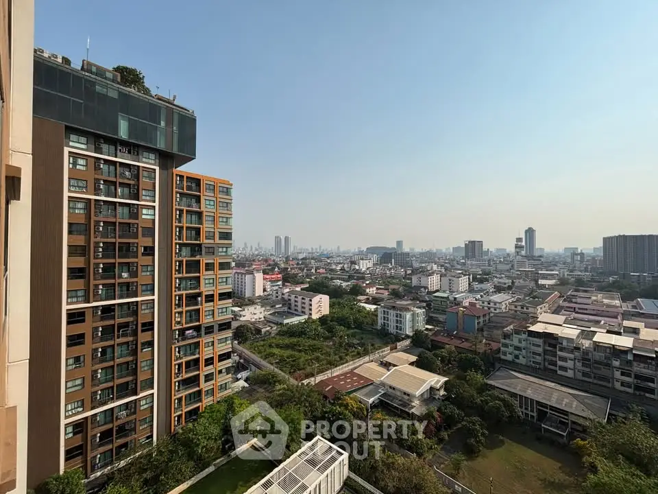 Stunning cityscape view from high-rise building balcony, showcasing urban skyline and lush greenery.