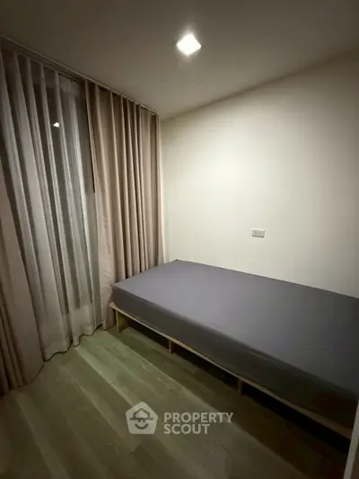 Cozy minimalist bedroom with single bed and floor-to-ceiling curtains