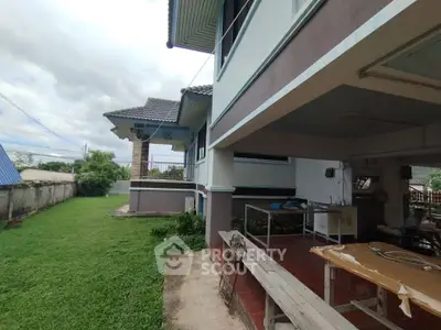 Spacious suburban home with lush green lawn and covered outdoor area, perfect for family gatherings.