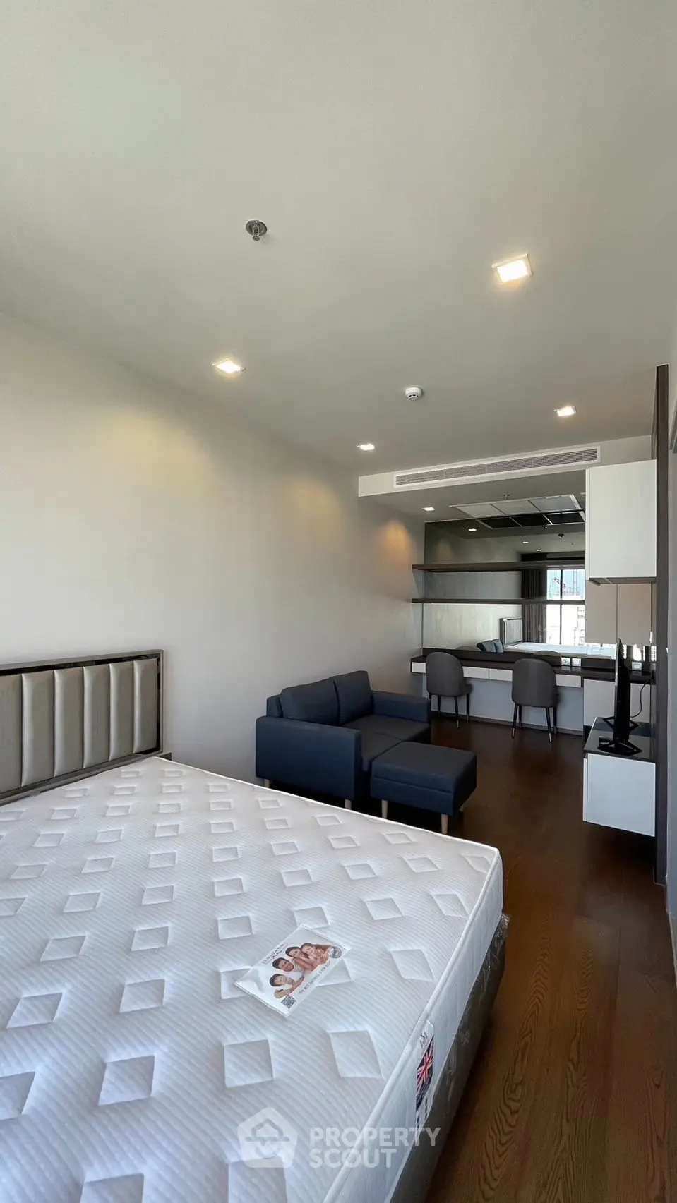 Spacious modern studio with open layout, featuring a cozy living area and sleek kitchen, perfect for urban living.