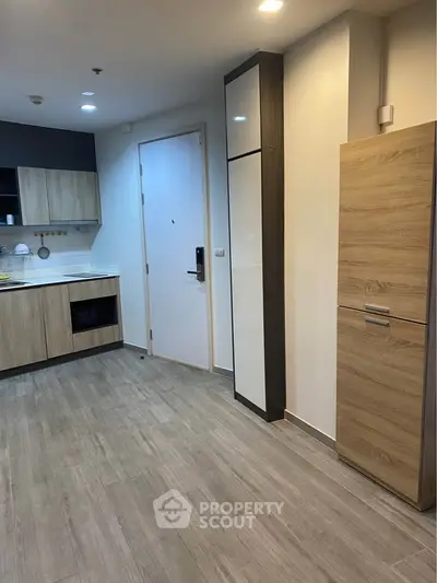Modern kitchen with sleek cabinetry and wood flooring in a contemporary apartment.