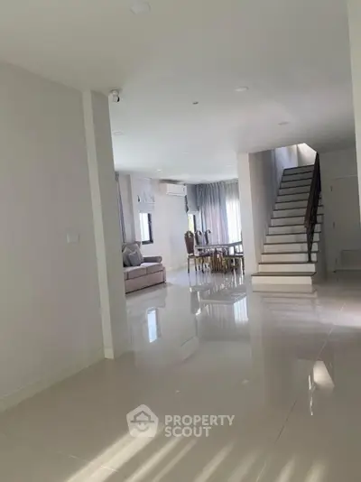 Spacious modern living room with sleek staircase and elegant dining area