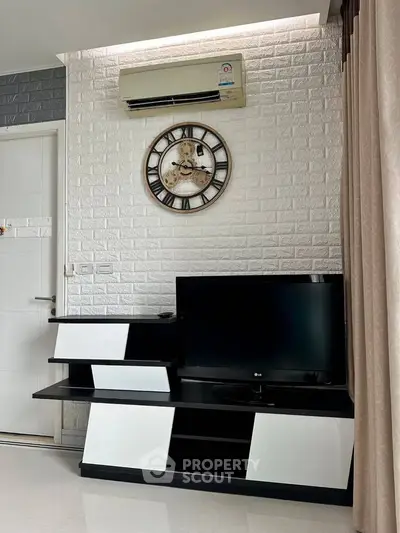 Modern living room with stylish TV stand, wall clock, and air conditioning unit.