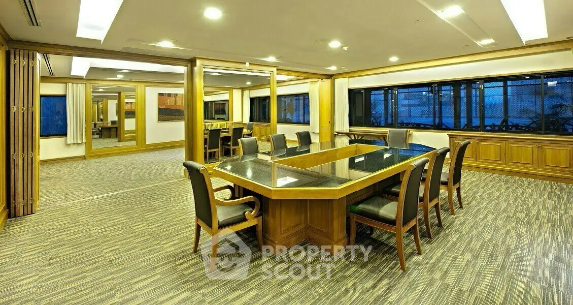 Spacious conference room with elegant wooden table and chairs, ideal for business meetings.