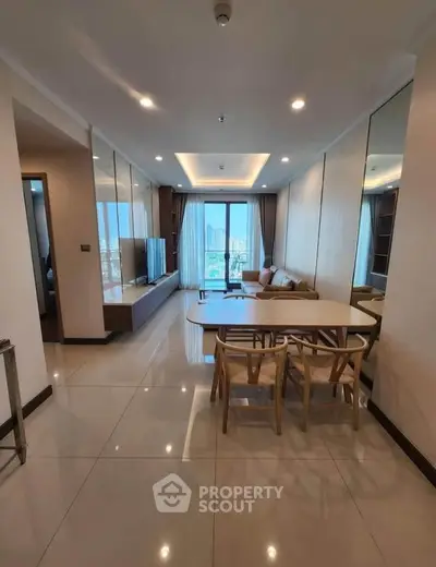 Spacious modern living room with dining area and city view balcony in luxury apartment.