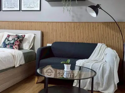 Cozy bedroom with stylish decor, featuring a bed, sofa, and modern floor lamp.