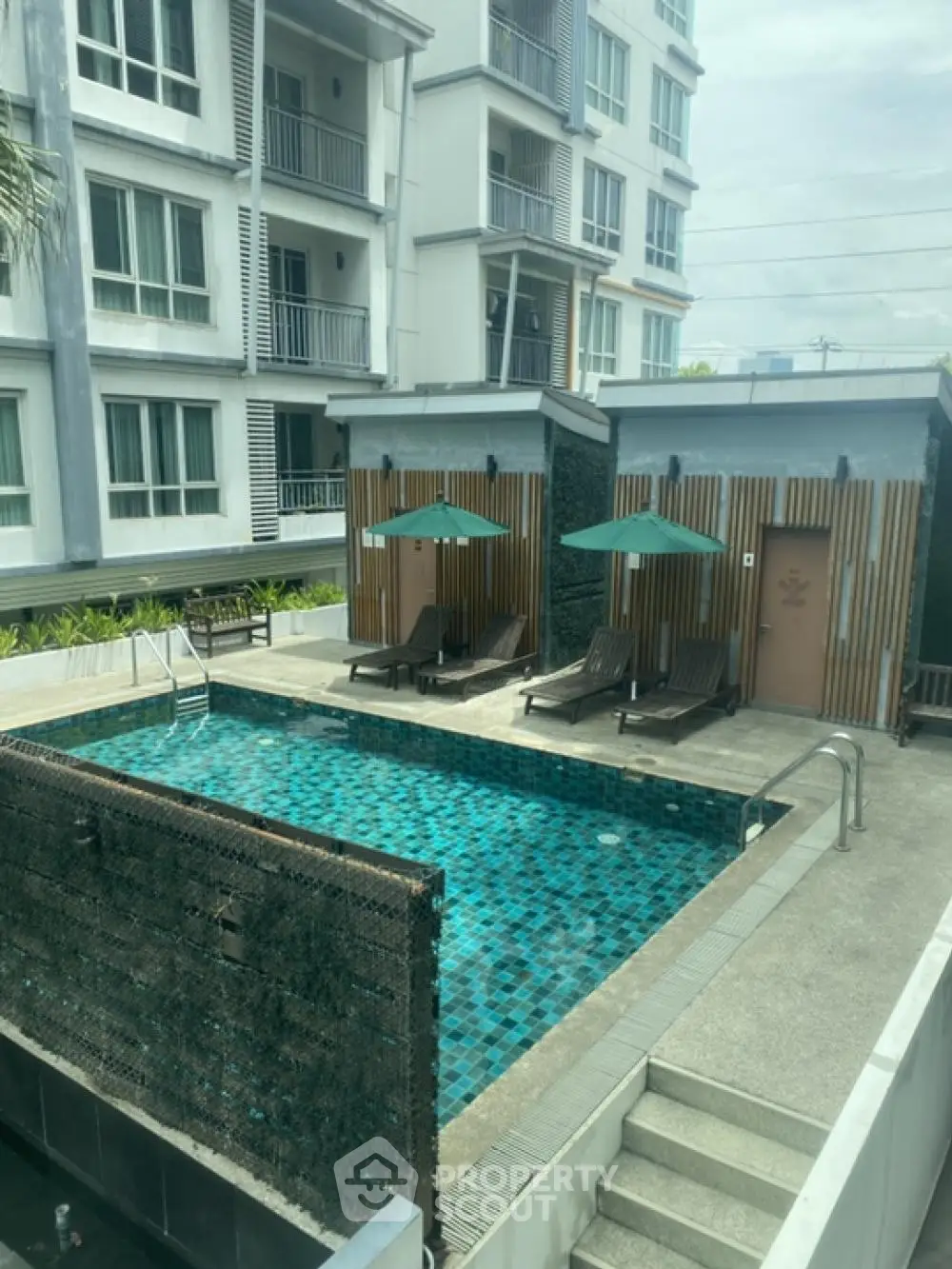 Modern apartment complex with inviting pool and sun loungers