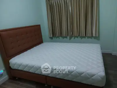 Cozy bedroom with plush bed and elegant curtains, perfect for restful nights.