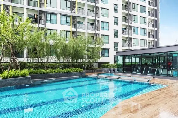 Modern apartment building with luxurious swimming pool and lush greenery.