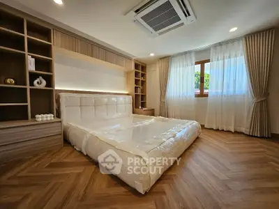 Luxurious bedroom with elegant wood flooring and built-in shelving