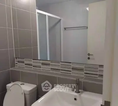 Modern bathroom with sleek gray tiles and contemporary fixtures.
