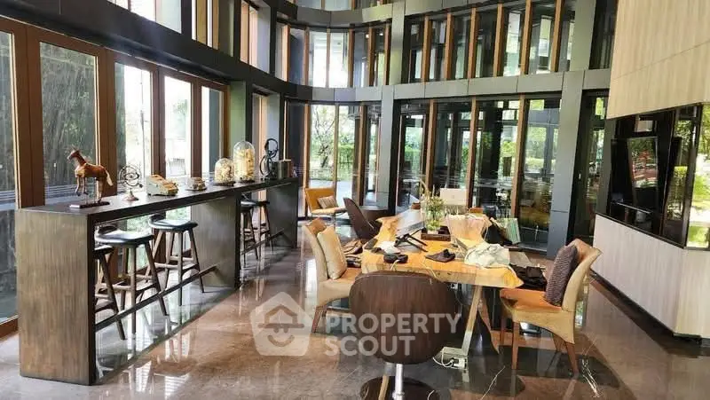 Luxurious modern living room with high ceilings and large windows, featuring elegant decor and stylish furniture.