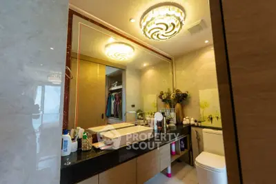 Luxurious bathroom with elegant lighting and modern fixtures, featuring a spacious vanity and stylish decor.