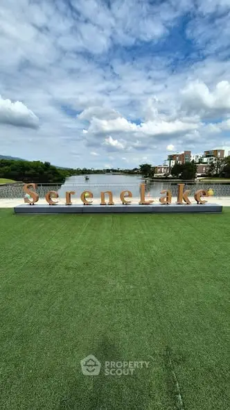 Scenic view of Serene Lake with lush greenery and modern buildings.