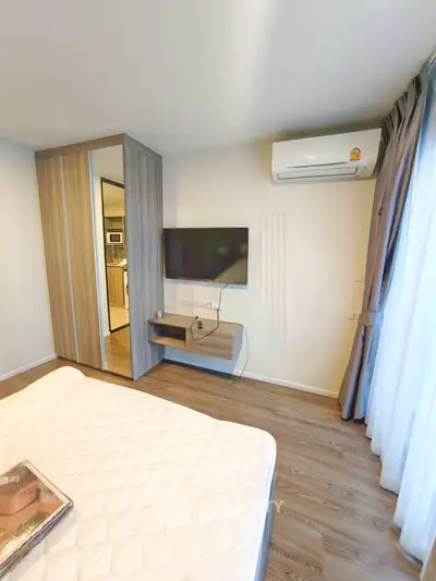 Modern bedroom with air conditioning and wall-mounted TV, featuring a sleek wardrobe and cozy ambiance.