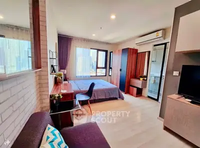 Modern studio apartment with city view, featuring cozy living area and stylish bedroom.