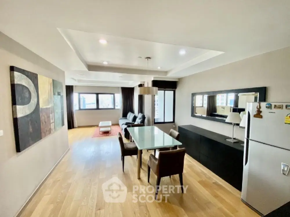 Spacious modern living room with dining area and large windows in a stylish apartment.