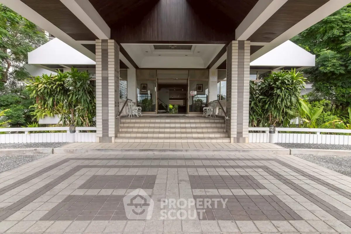 Elegant building entrance with lush greenery and modern design