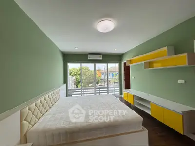 Spacious bedroom with modern design and large windows offering natural light and garden view.