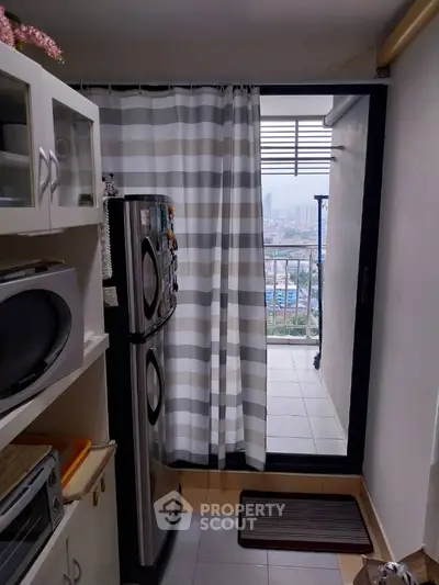 Compact kitchen with balcony view and modern appliances