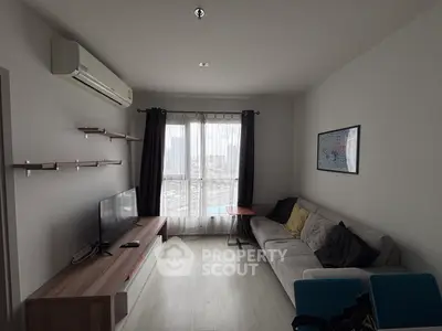 Modern living room with city view, featuring sleek furniture and natural light.