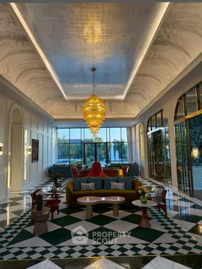 Luxurious living room with elegant chandelier and large windows offering a stunning view.